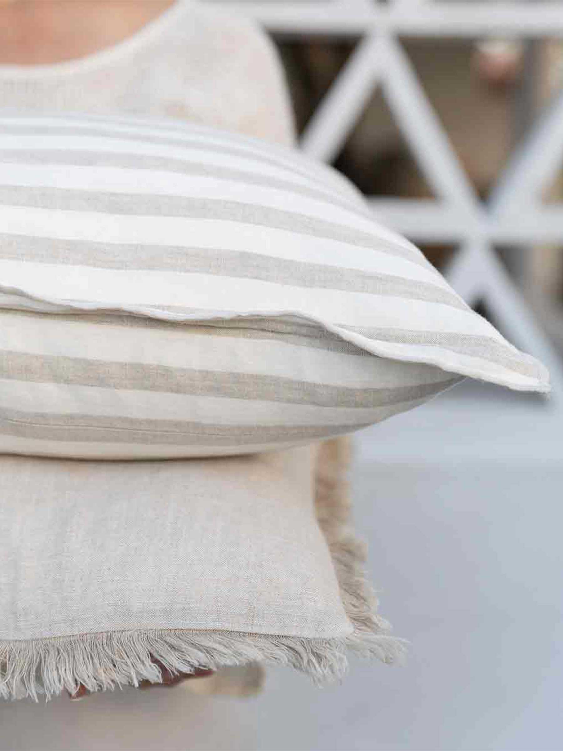 Cushion stack with Milo Natural and Lucas Natural Stripe being held