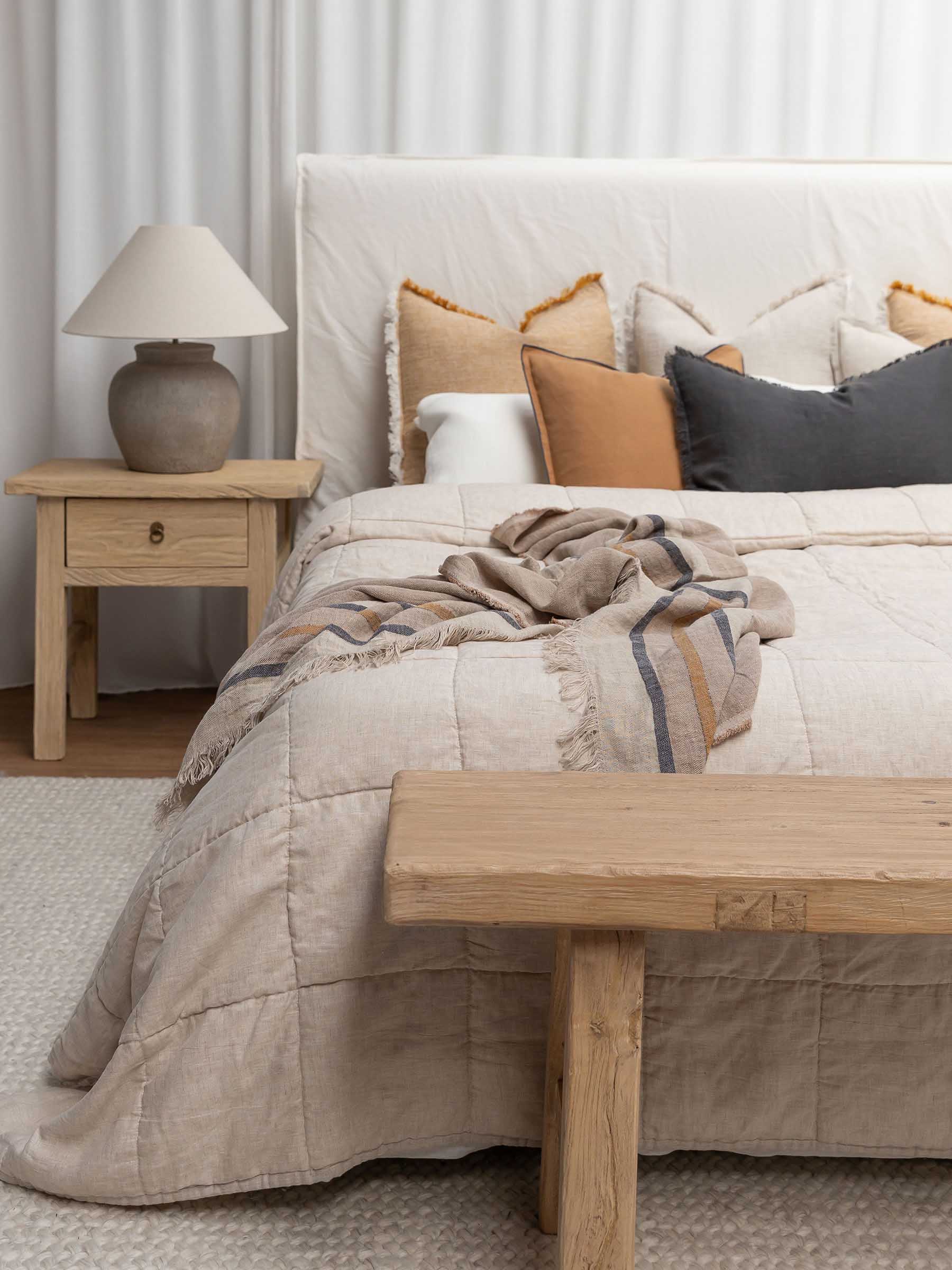 Arlo sand dune striped linen throw with fringed edge styled on bed with neutral bedding creating layered textural bedroom aesthetic
