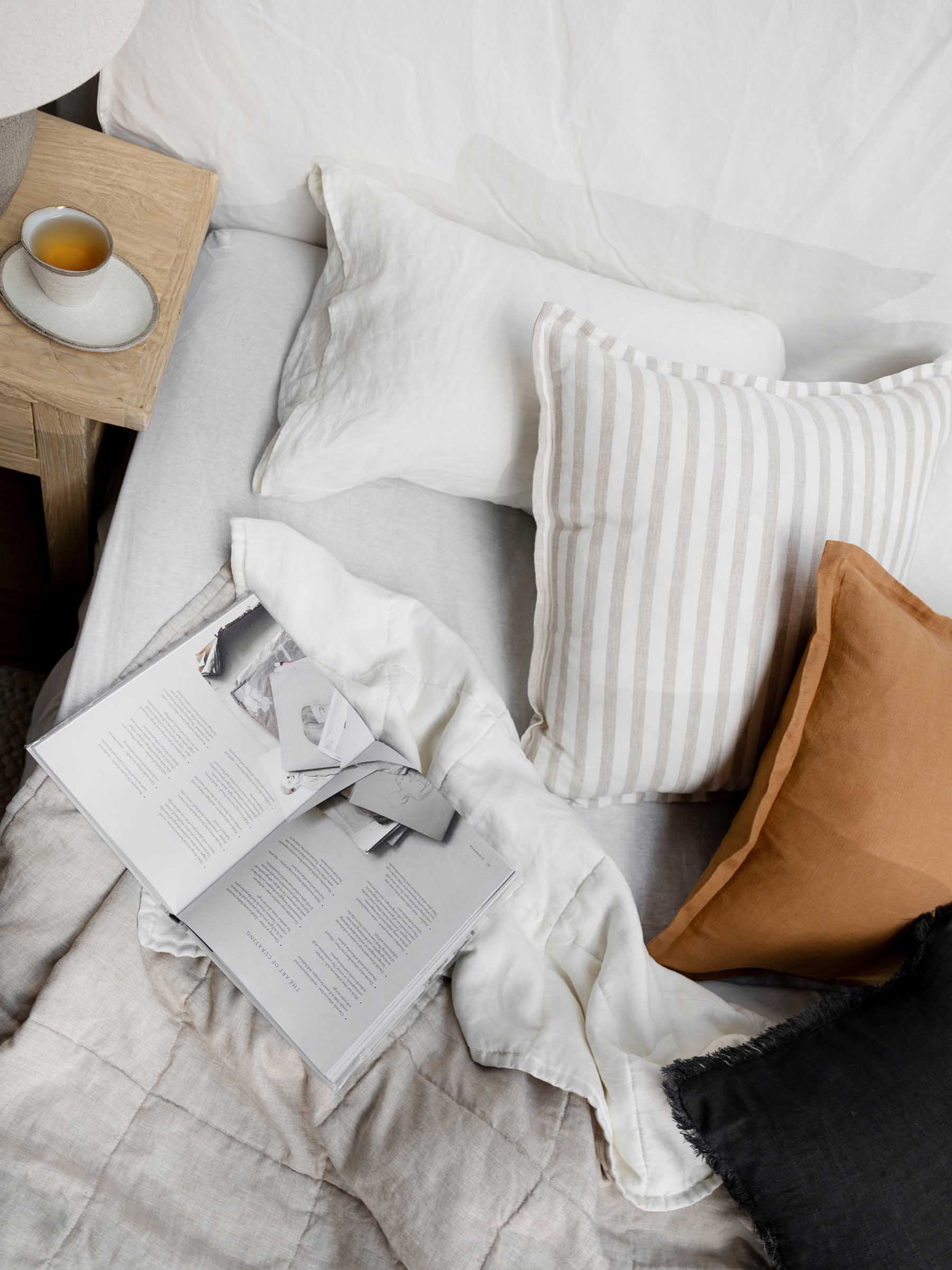 Felix linen cushion in Butterscotch colour on lifestyle bed setting made from French Flax linen with flanged border