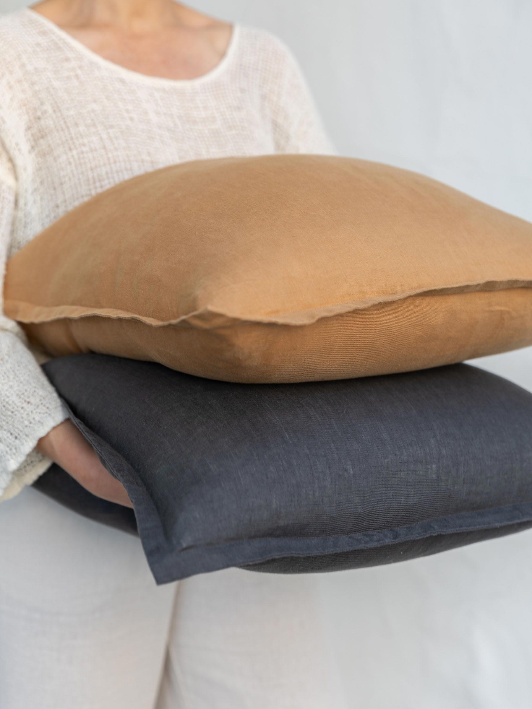 Felix cushion in Butterscotch stacked with contrasting cushion colour showing flanged border made from French Flax linen