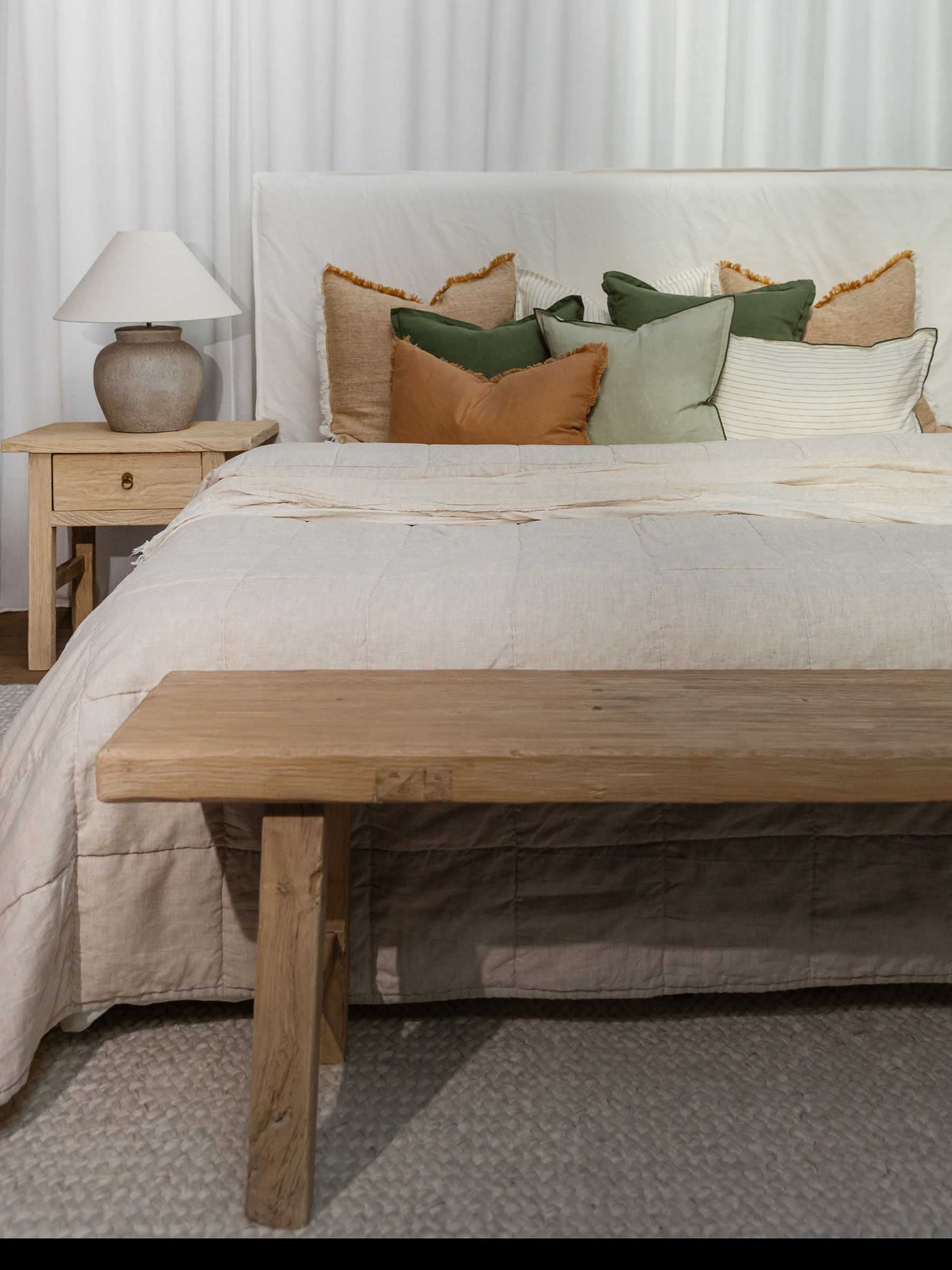 Harlow French Flax linen cushion in Gumleaf colour with basil overstitching trim styled with neutral linen bedding in bedroom