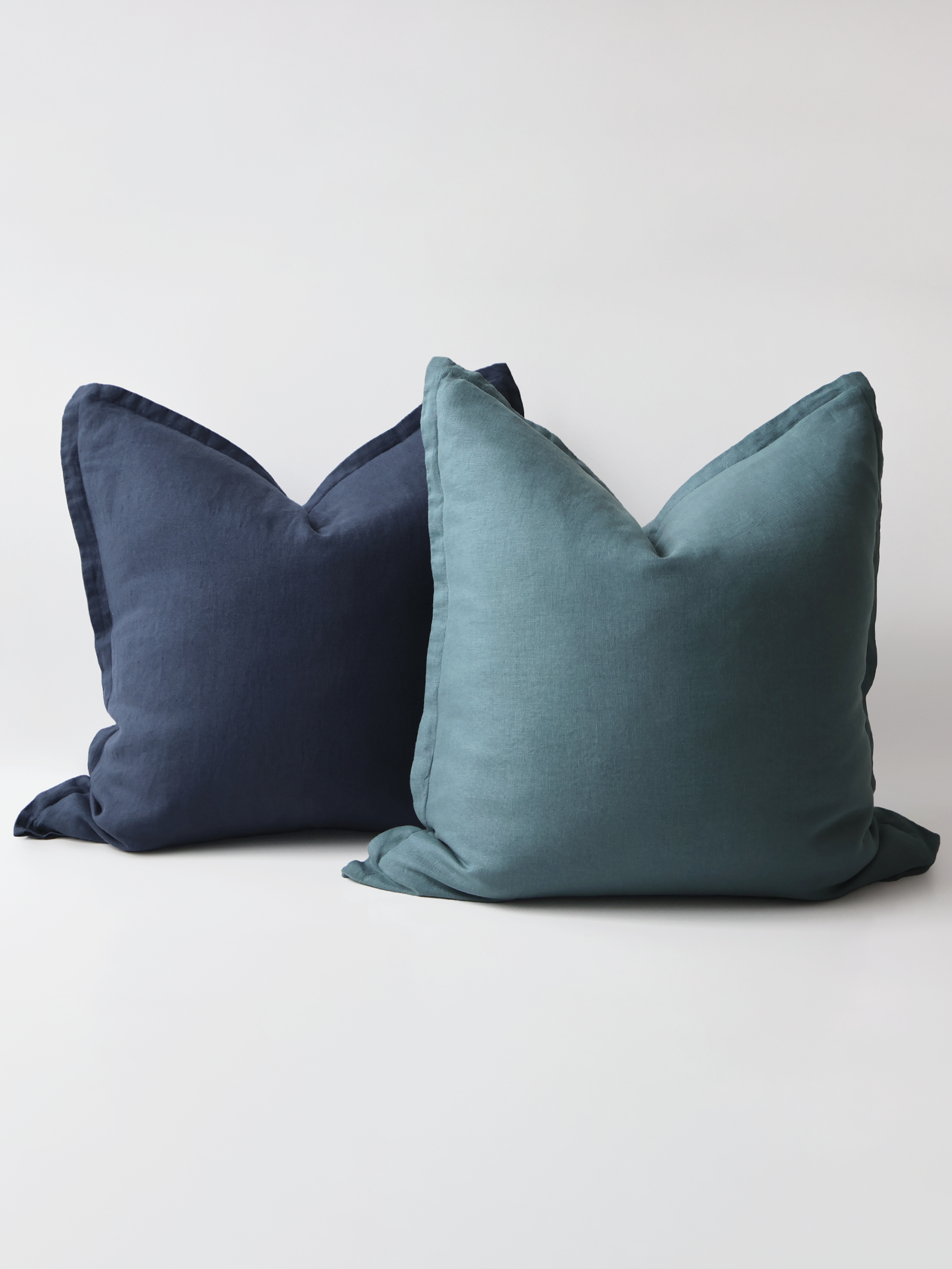 A video demonstration showing the Reversi® reversible linen flange square cushion design in petrol and navy and how it flips inside out for a whole new look