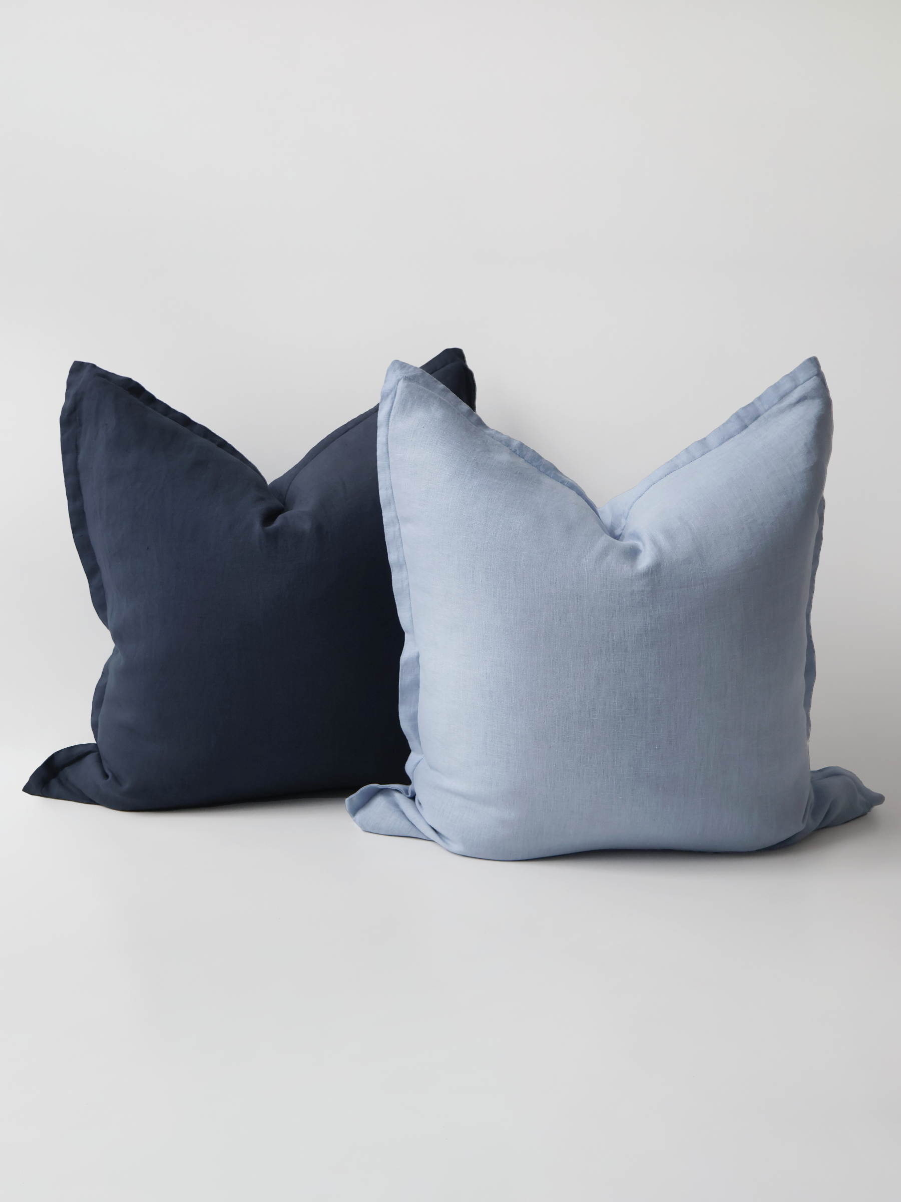 A video demonstration showing the Reversi® reversible linen flange square cushion design in sky and navy and how it flips inside out for a whole new look