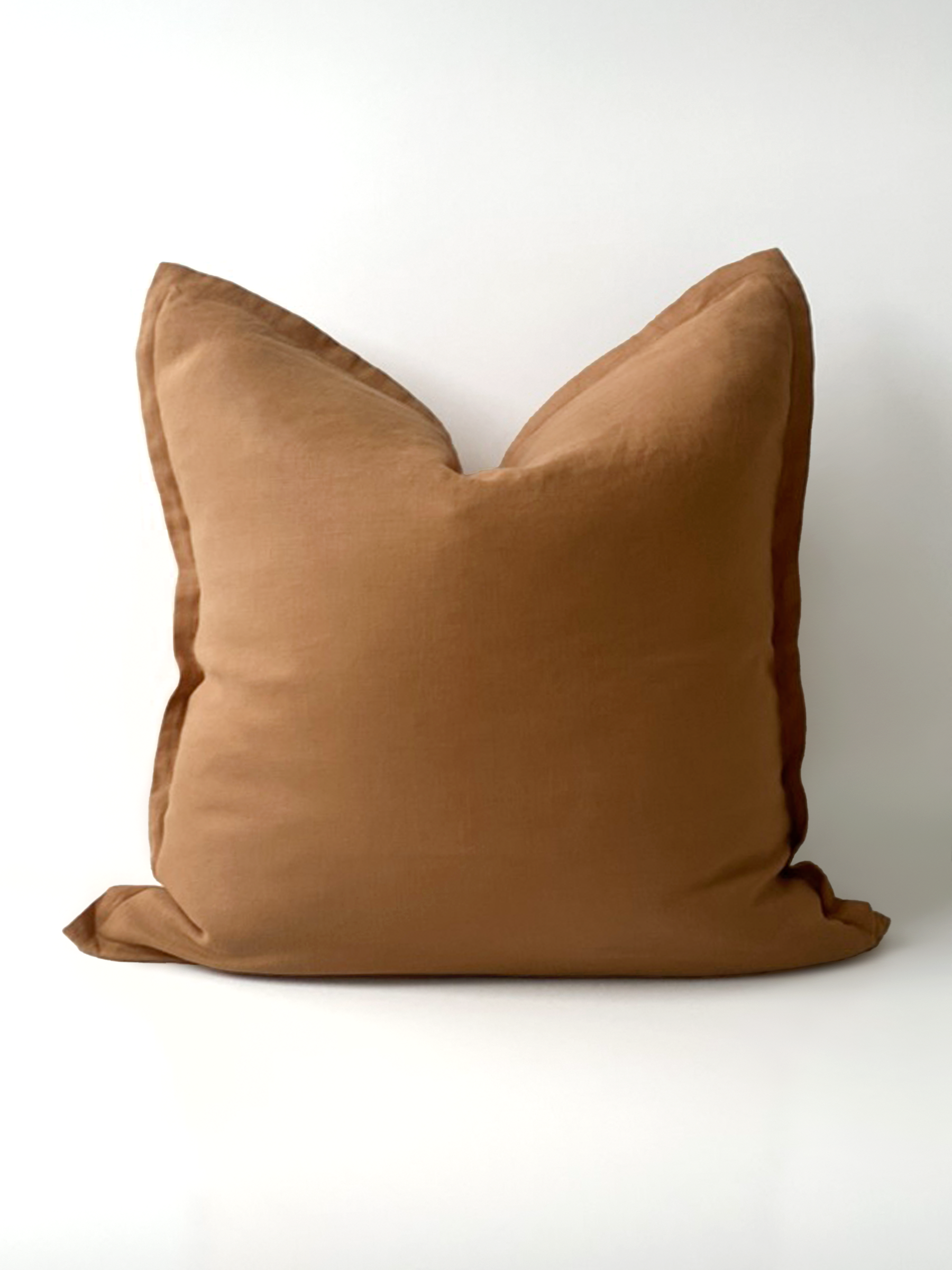 Reversi® reversible linen flange square cushion flipped to show full butterscotch colour of the two in one cushion cover design in a studio