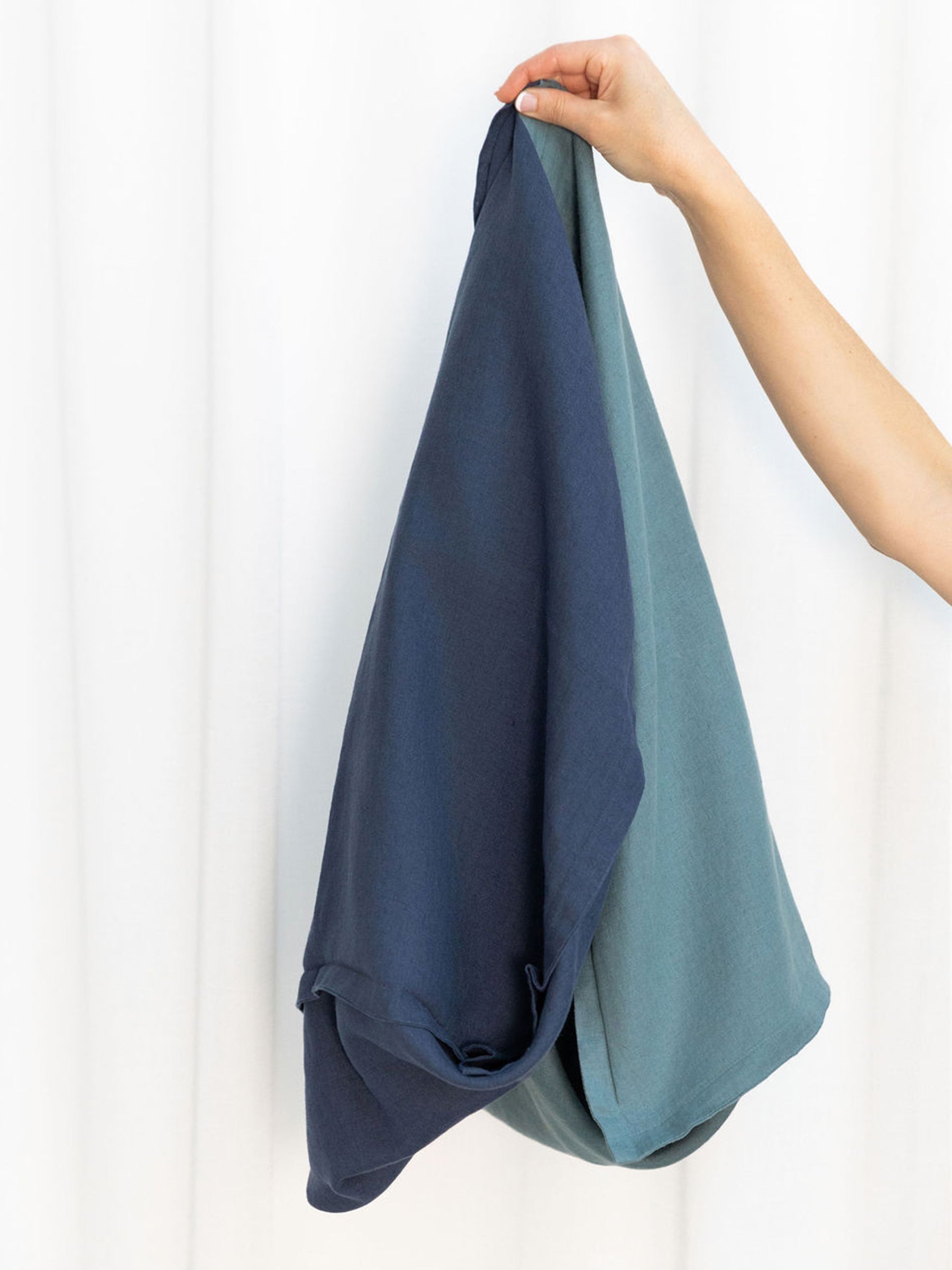 Reversi® reversible linen flange square cushion in petrol and navy colours showing both sides of the two in one cushion cover design