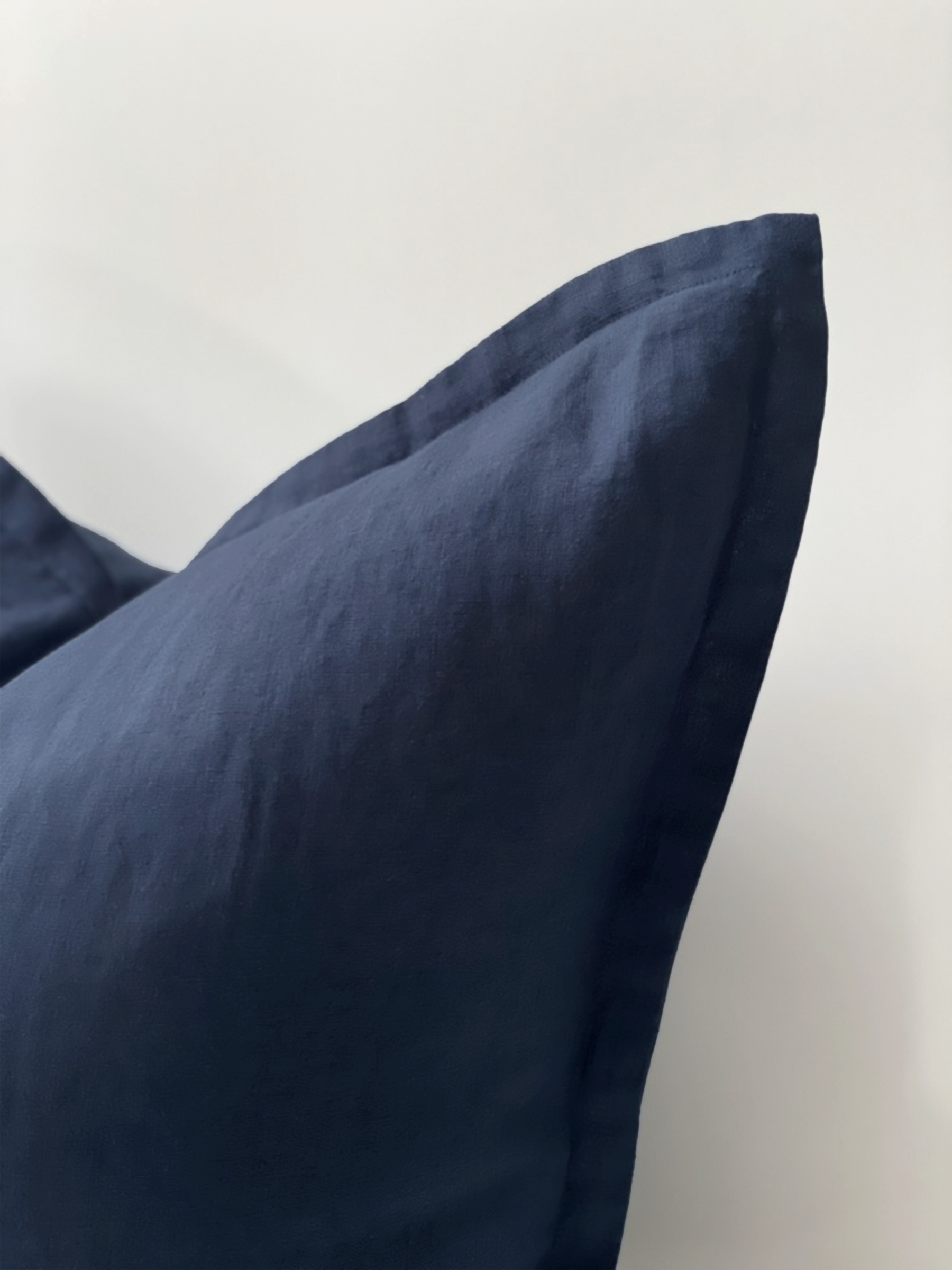 Reversi® reversible linen flange square cushion flipped to show navy colour texture close up of the two in one cushion cover design in a studio